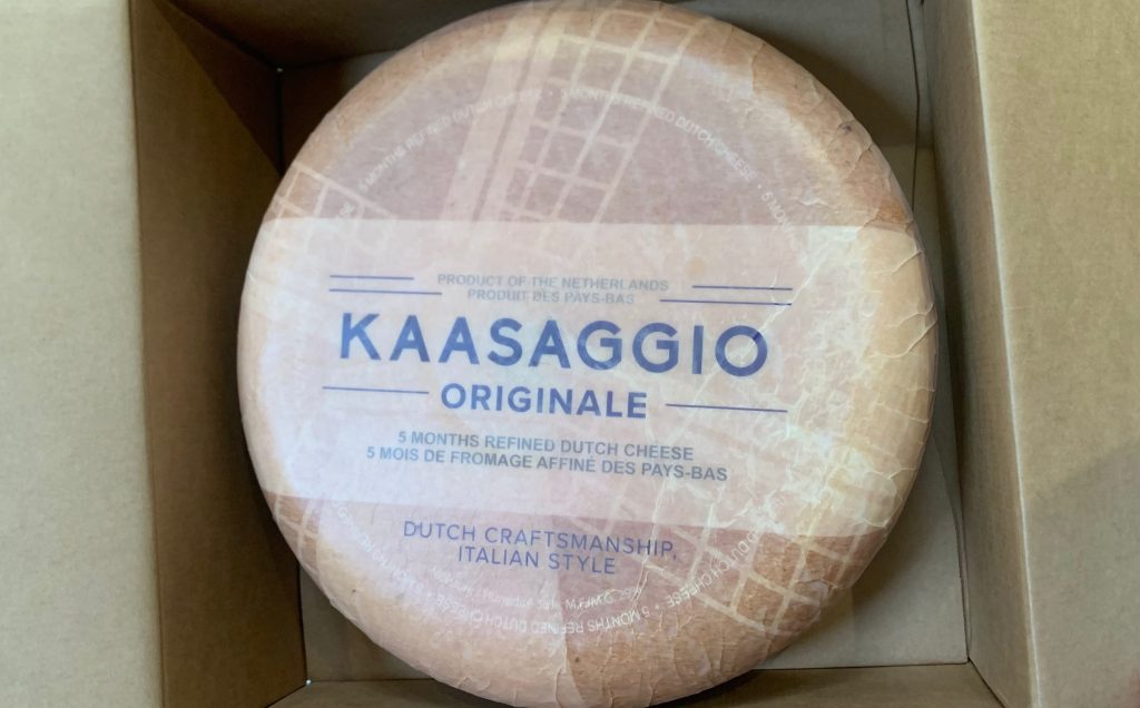 A wheel of gouda inside an opened box